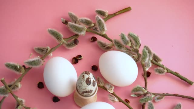 Huevos-de-Pascua-sobre-un-fondo-rosado-con-una-ramita-de-sauce