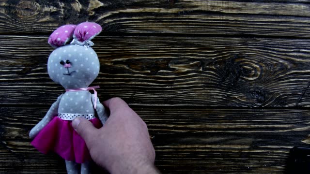 Toy-plush-hare-on-a-wooden-background