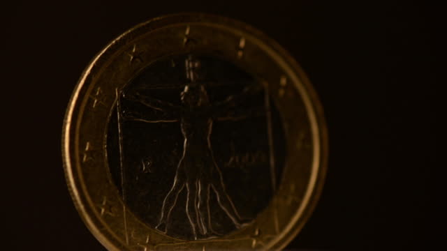 Eine-Euro-Münze-dreht-sich-auf-schwarzem-Hintergrund.