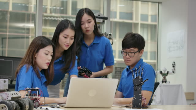 Jóvenes-ingenieros-creativos-asiáticos-reuniéndose,-programación-para-robótica-universal-colaborativa-en-portátil-en-taller.-Personas-con-concepto-de-tecnología-o-innovación.
