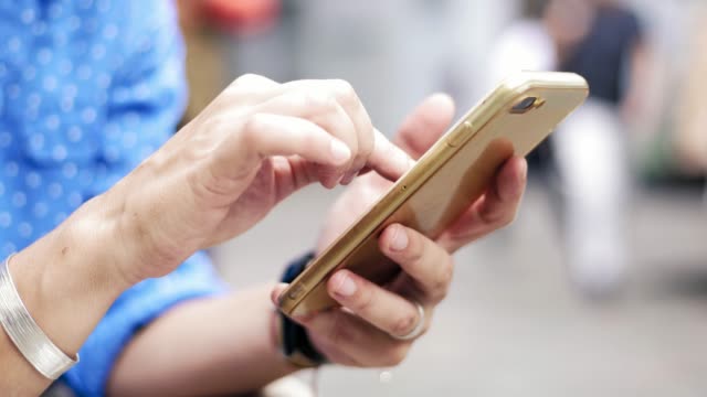 Close-up-footage-of-woman's-hands-holding-smartphone-and-browsing-website.