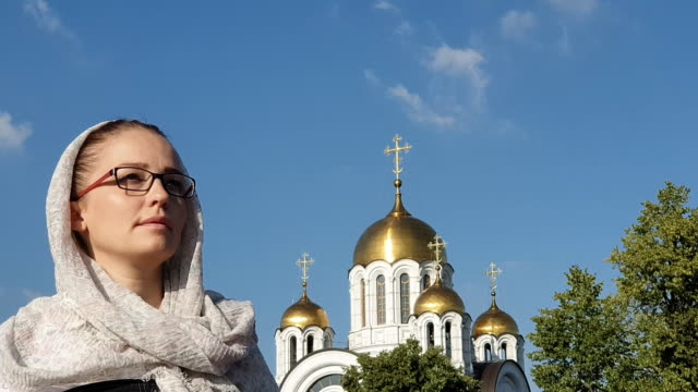 Orthodoxe-Lifestyle-Frau-im-Schal-steht-auf-dem-Hintergrund-der-orthodoxen-Kirche