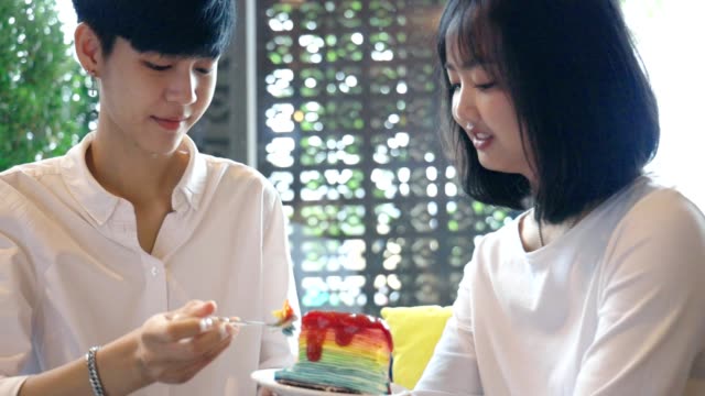 Junge-asiatische-Lesben-Paar-Fütterung-süßen-Regenbogen-Kuchen,-LGBT-Liebe-Moment-Zeitlupe