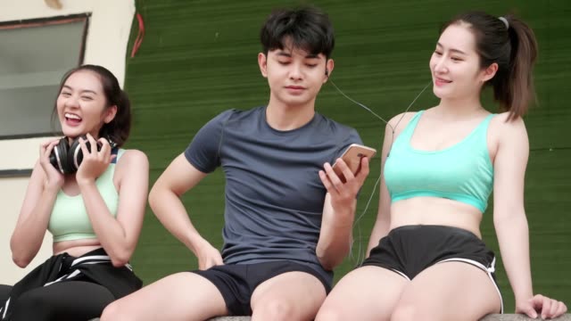 Asiatische-junge-Männer-und-Mädchen-Relexing-Übung-nach-Sport-laufen