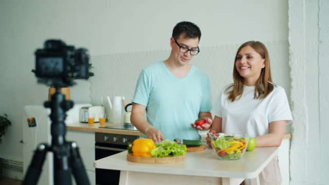 Happy-family-recording-video-about-organic-vegetables-talking-using-camera