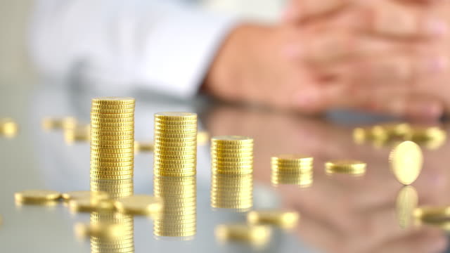 Businessman-stacking-golden-coin-towers.-Video-shot-4K-50fps.