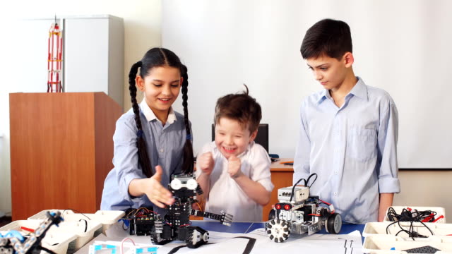 Gruppe-von-Kindern-wählen-Teile-von-Roboterspielzeug-für-den-Bau-von-Robotern-in-der-Schule-Unterricht