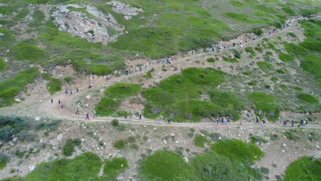 A-group-of-people-running-down-the-mountainside.-The-Mountains-Of-The-Caucasus.-Russia
