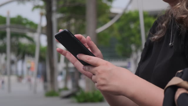 Frau-Hände-mit-Smartphone-auf-einer-modernen-touristischen-Stadtstraße