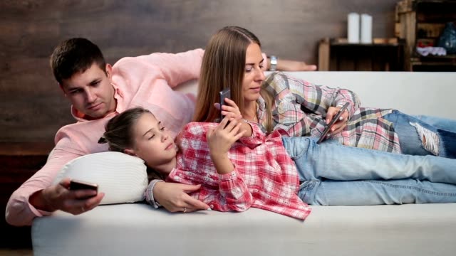 Junge-Familie-verbringt-viel-Zeit-mit-elektronischen-Geräten