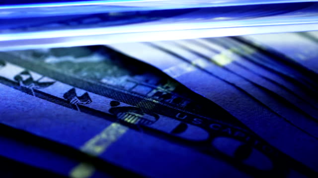 Überprüfung-der-Dollar-Banknoten-unter-UV-Detektor.-Gefälschte-Konzept.