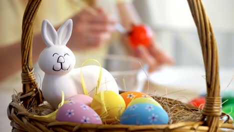 Happy-Easter!-Mother-and-her-little-daughter-wearing-funny-rabbit-ears-coloring-easter-eggs