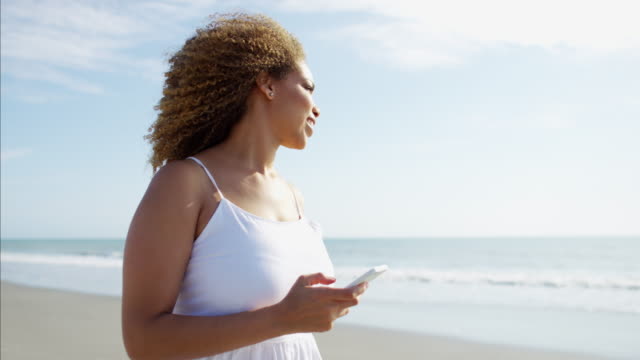 African-American-female-with-smart-phone-at-sunset