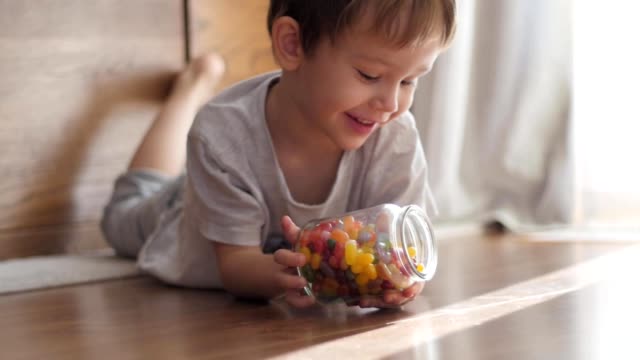 Jungen-spielen-mit-Glas-mit-Süßigkeiten