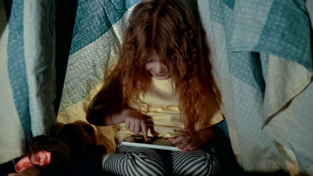 Little-cute-girl-in-teepee-tent-in-bedroom-evening.