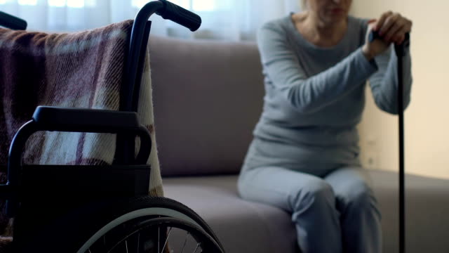 Traurige-senior-Frau-Blick-auf-Rollstuhl,-Gefühl,-einsam-und-verlassen,-depression