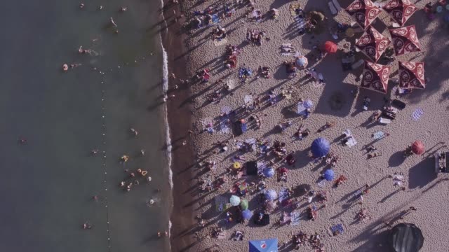 Aerial-view-maritime-city-on-Black-sea.-Seashore-and-vacationers-people-on-the-beach,-beach-umbrellas