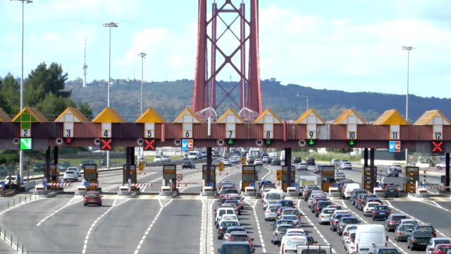 Durch-den-Punkt-der-Mautautobahn,-Mautstation-vorbeifahrende-Autos-in-der-Nähe-der-Brücke.-Lissabon,-portugal