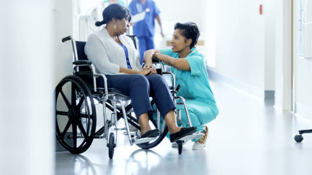 Afrikanische-amerikanische-weibliche-Personal-und-Patienten-im-Rollstuhl