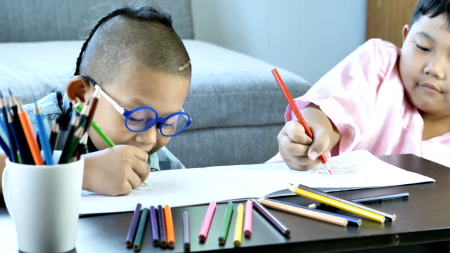 Boys-with-disability,-brain-disorders-And-Left-eye-is-not-visible-from-brain-surgery.-Have-fun,-enjoy-drawing-or-write-in-book-with-friends-at-home.