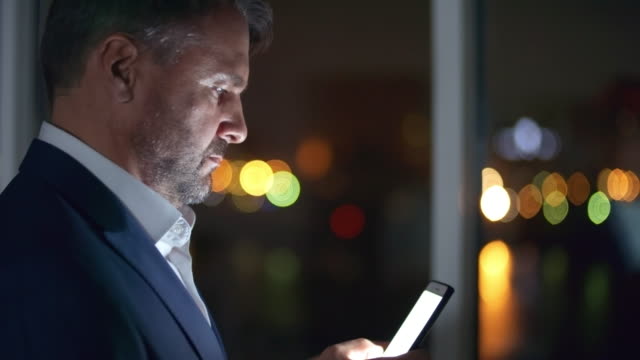 Businessman-Typing-a-Message-on-Smartphone-in-the-Night
