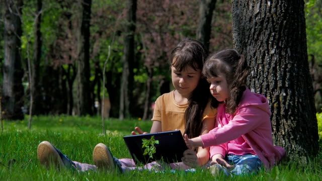 Los-niños-en-la-naturaleza-juegan-en-la-tableta.