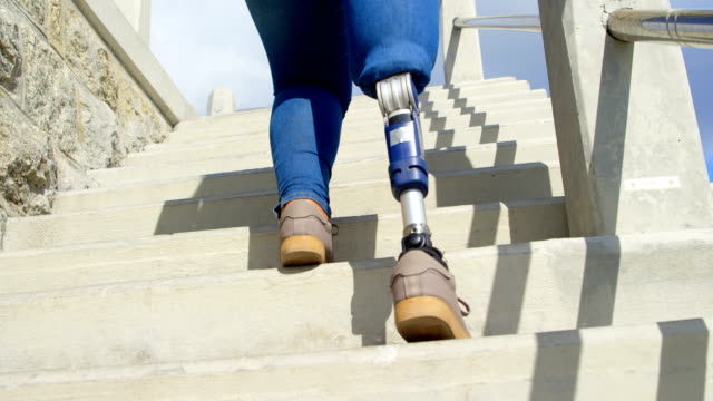 Vista-de-ángulo-bajo-de-mujer-con-discapacidad-caminar-arriba-de-4k