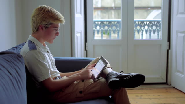 Stylish-teenage-boy-using-tablet.