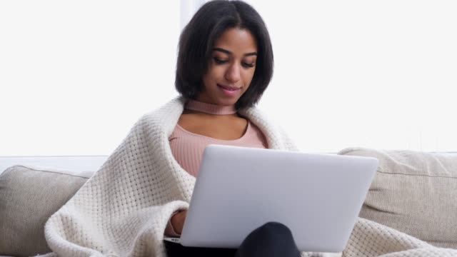Teenage-girl-using-laptop-on-sofa