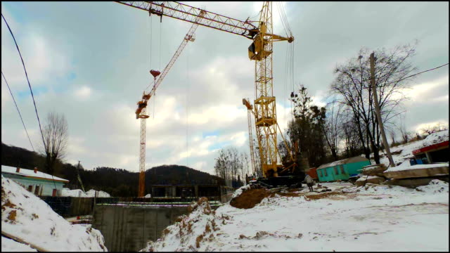 Timelaps-of-winter-construction.-Work-of-cranes-on-construction.-Fast-moving-clouds