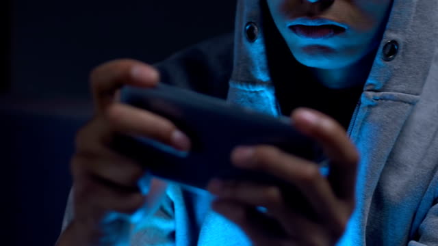 Afro-amerikanischer-Junge-spielt-Flugsimulator-Handyspiel-auf-Smartphone-in-der-Nacht