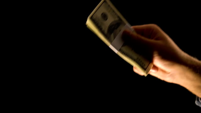 Hand-taking-dollars-on-black-background,-dirty-money-concept,-payment-for-crime