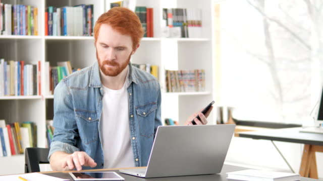 Multitasking,-Casual-Redhead-Man-Using-Phone,-Tablet-und-Laptop