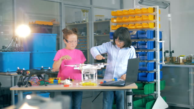 Children-repairing-drone-model-in-modern-technology-school-class.-4K.