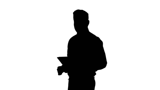 Silhouette-Happy-businessman-walking-in-using-tablet-turning-on-something-or-opening-something
