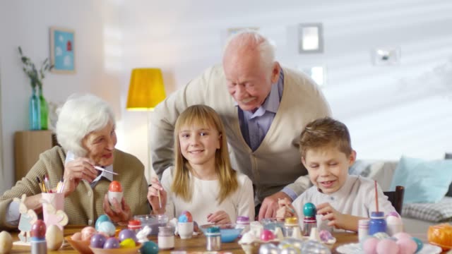 Portrait-of-Family-Smiling-while-Painting-Eggs