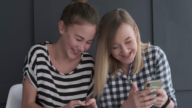 Teen-girls-laughing-and-using-mobile-phone