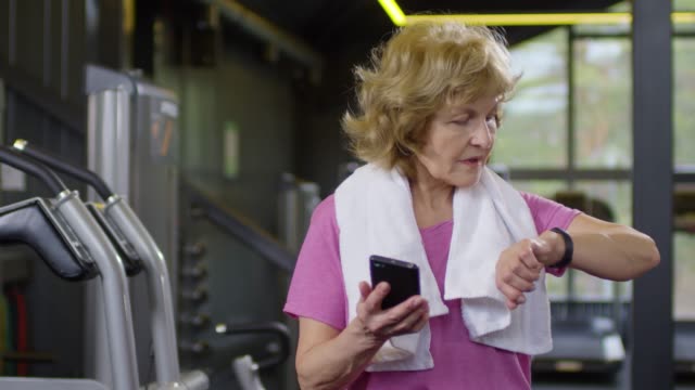 Mujer-vieja-usando-dispositivos-en-el-gimnasio