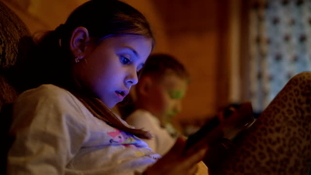 4K-two-children-sitting-immersed-in-electronic-gadgets