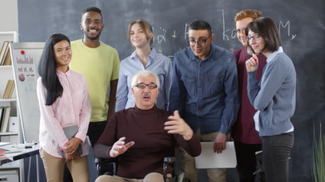 Portrait-of-Smiling-Professor-in-Wheelchair-and-Students