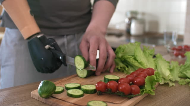 Handicapped-Man-with-Bionic-Prosthesis-Cutting-up-Vegetables