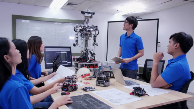 Asiatischer-Mann-anwesend-für-Roboter-Projekt-mit-Team-im-Besprechungsraum.-Technologie--und-Innovationskonzept.
