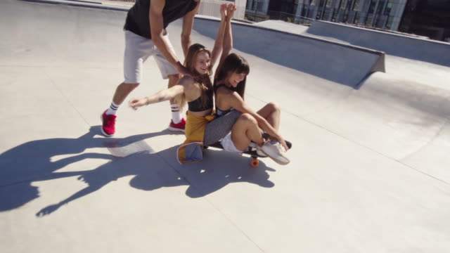 Amigos-creando-un-divertido-video-en-el-parque-de-skateboard.