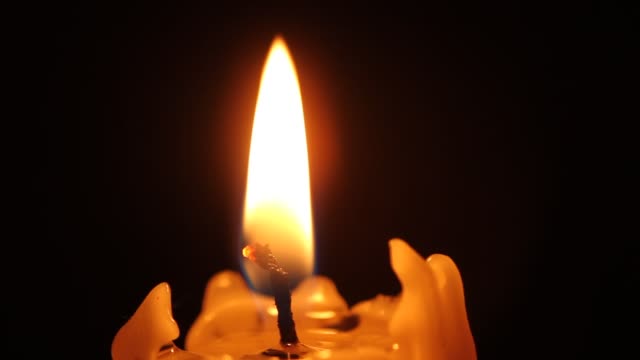 Closeup-of-candle-flame-on-black.-Old-white-candle