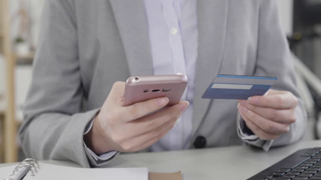 woman-hands-holding-mobile-phone-and-credit-card