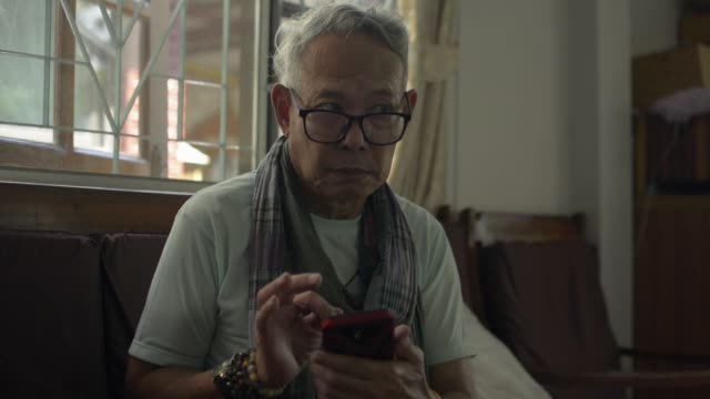 Senior-alte-graue-Haare-Mann-mit-Handy-für-soziale-Online-Kommunikation-zu-Hause.