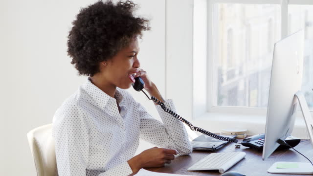 Young-black-woman-on-the-phone-in-an-office,-close-up