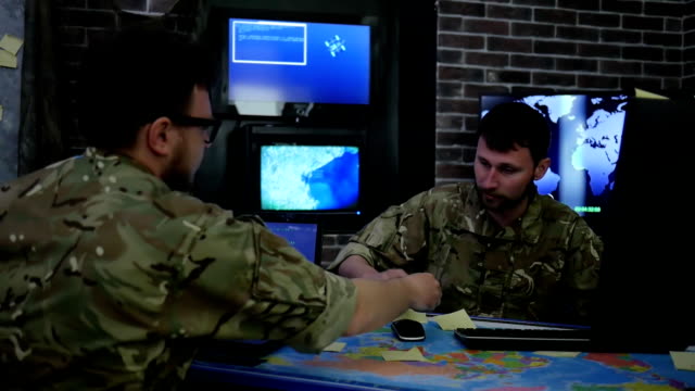 Zwei-schwere-Soldaten-in-uniform,-Krieg-Mitte-Überwachungsraum,-arbeiten-für-Laptop,-suchen-Sicherheitssystem