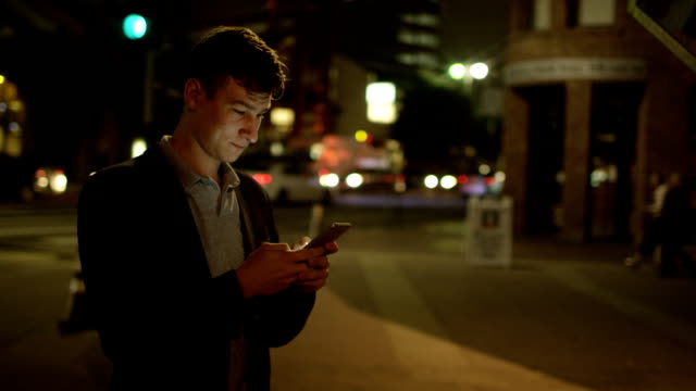 Young-attractive-man-is-texting-on-a-street