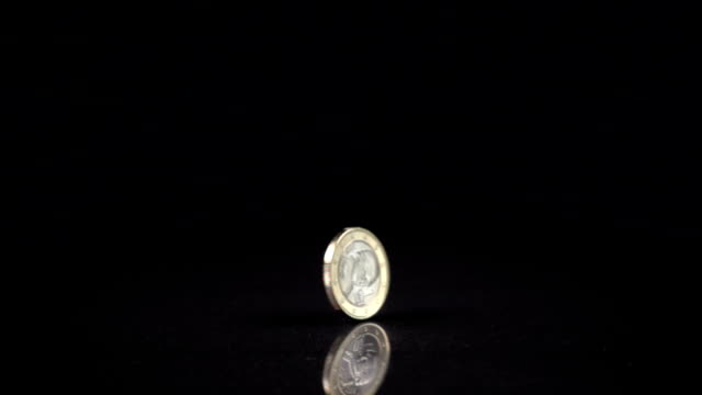 ein-Euro-Münze,-die-Spinnen-auf-einem-schwarzen-Hintergrund